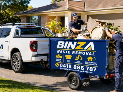 BINZA Waste Removal team loading rubbish onto a trailer