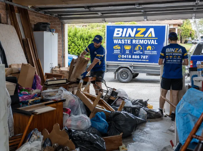 BINZA Waste Removal team loading a trailer with waste for collection